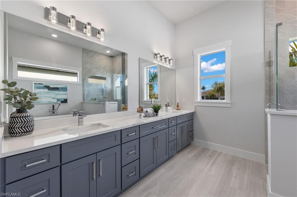 Bathroom featuring walk in shower, vanity, and hardwood / wood-style flooring
