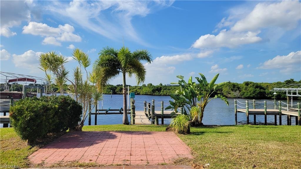 Dock area featuring a water view, a lawn, and boat lift