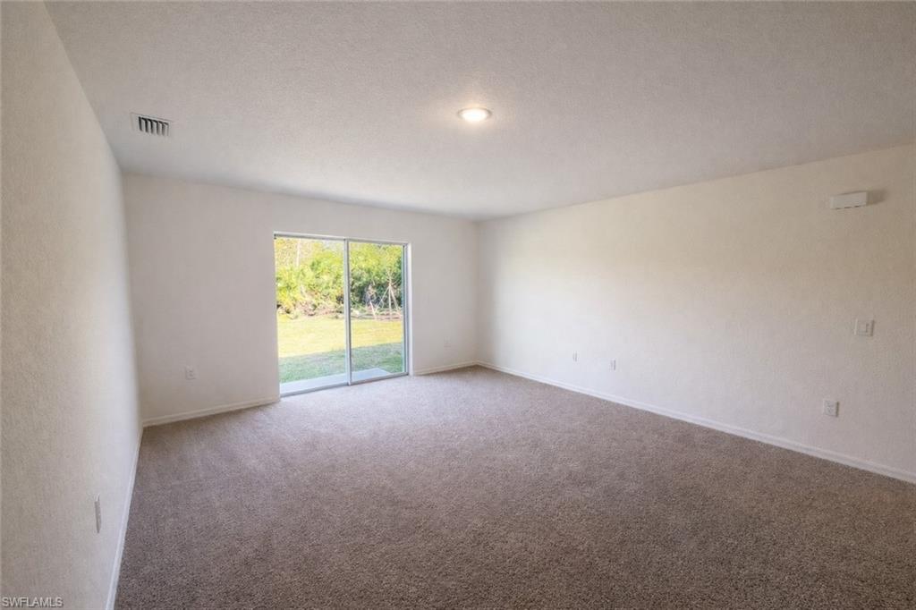 Spare room featuring carpet and a textured ceiling
