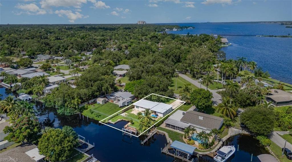 Aerial view of residential area featuring a large body of water and property boundaries highlighted