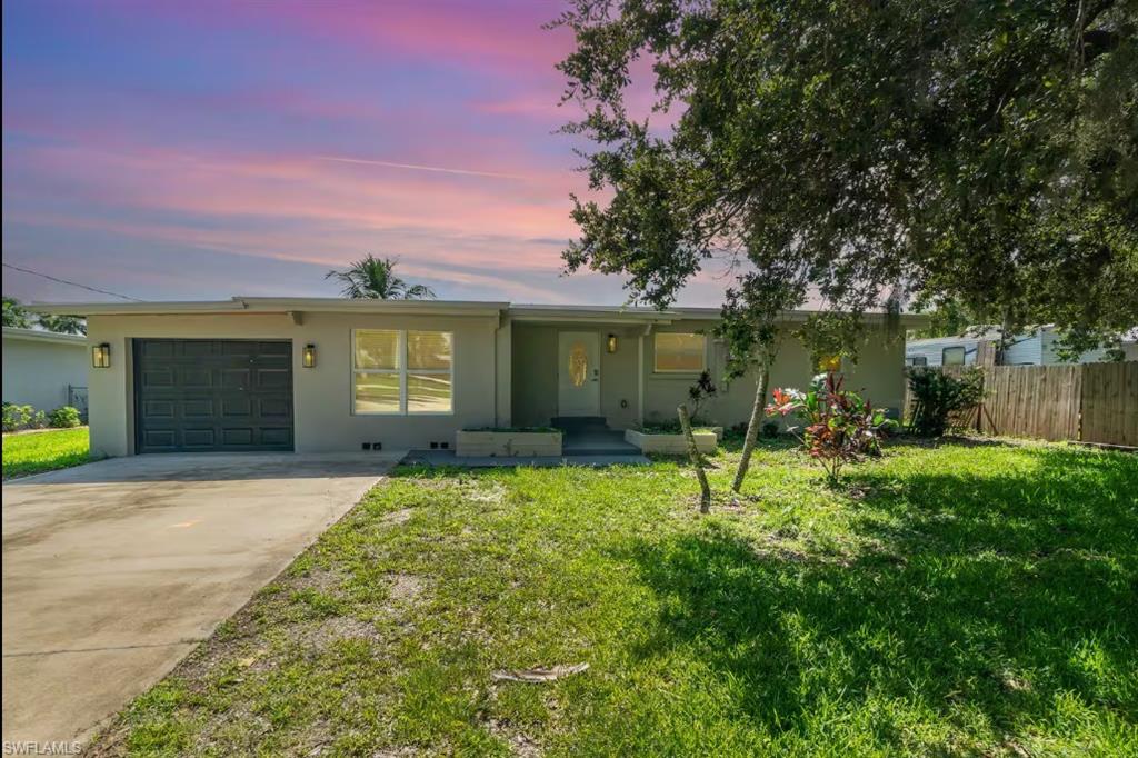 Single story home featuring stucco siding, an attached garage, and driveway