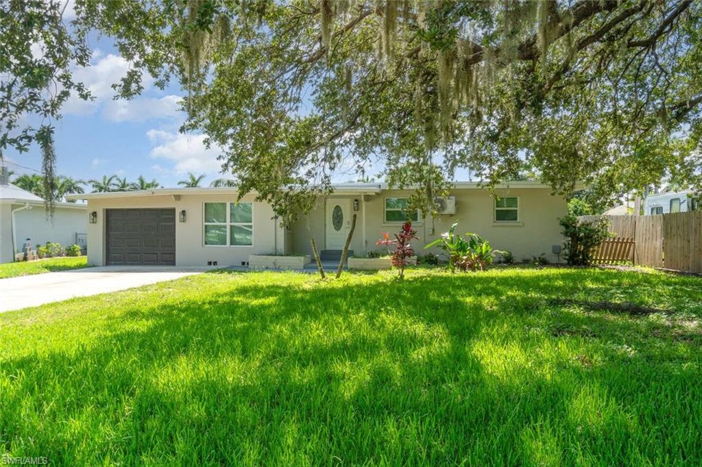 Ranch-style home with a garage, driveway, and stucco siding