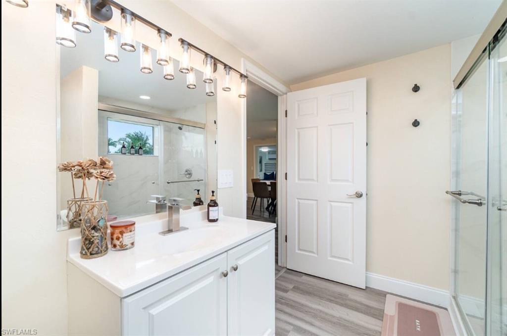 Bathroom featuring vanity, a shower stall, and wood finished floors