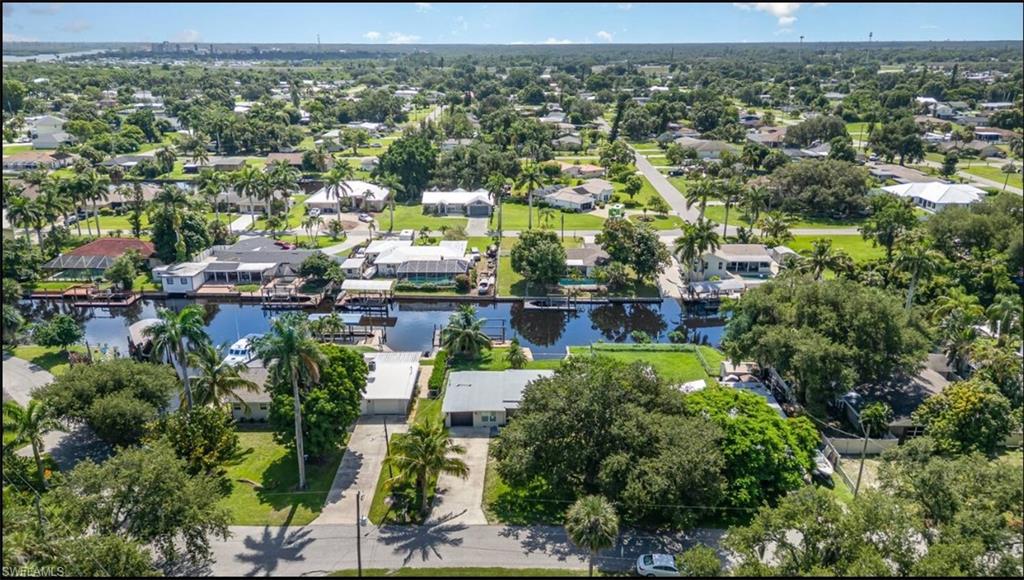 Aerial view of property and surrounding area with a large body of water and nearby suburban area