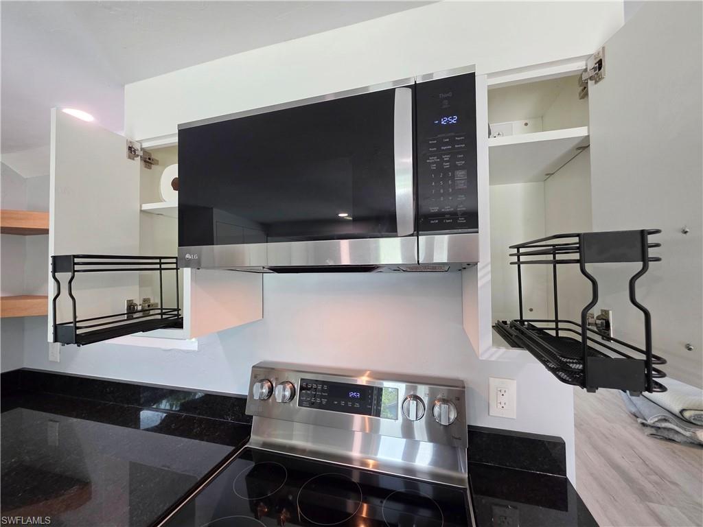 Kitchen featuring appliances with stainless steel finishes and open shelves
