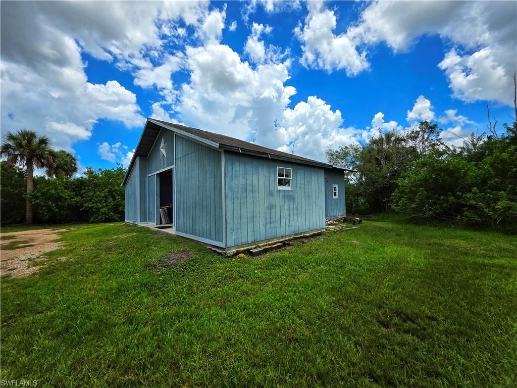 View of home's exterior with an outbuilding and a lawn