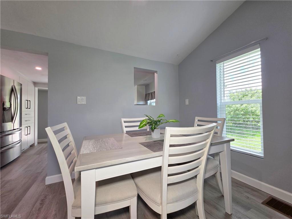 Dining space featuring vaulted ceiling and wood finished floors
