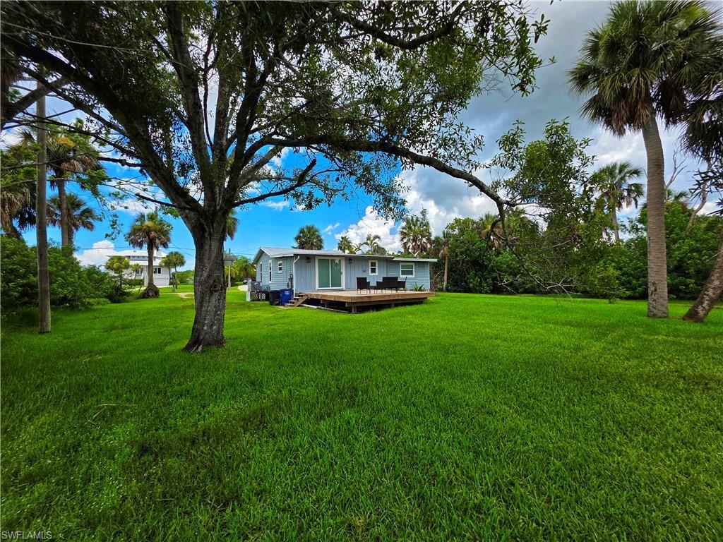 View of grassy yard featuring a deck