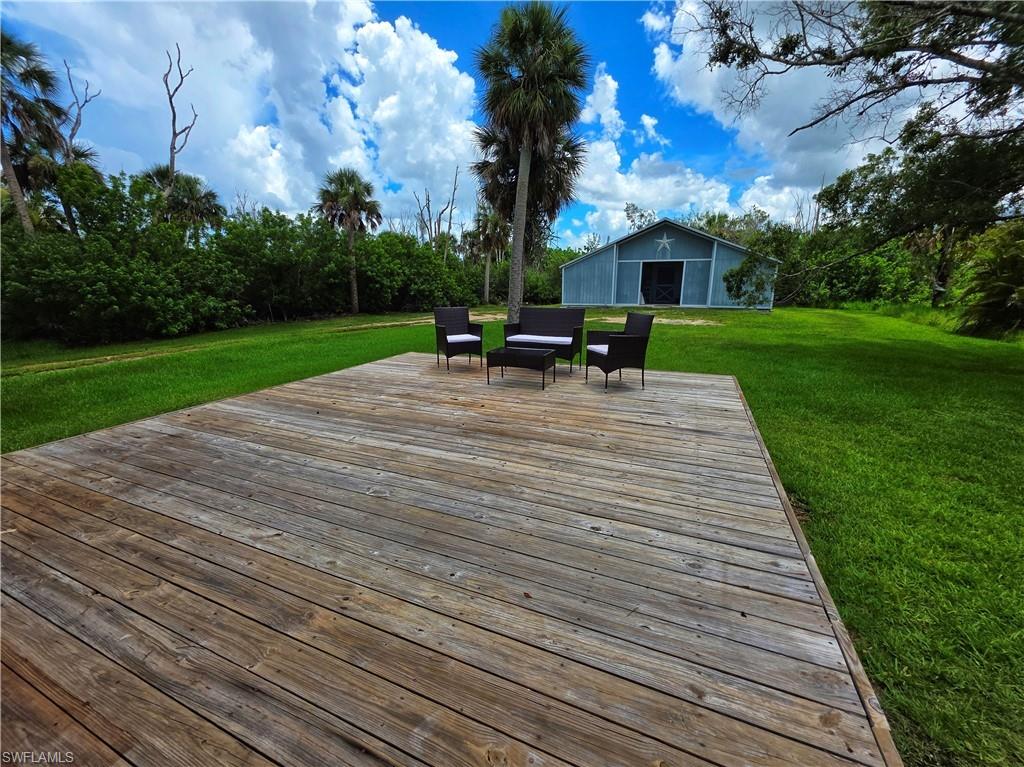 Deck with a yard and view of wooded area