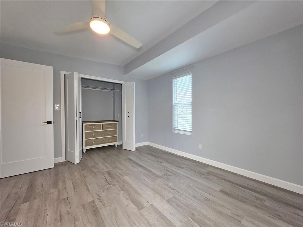 Unfurnished bedroom with wood finished floors, a closet, and ceiling fan