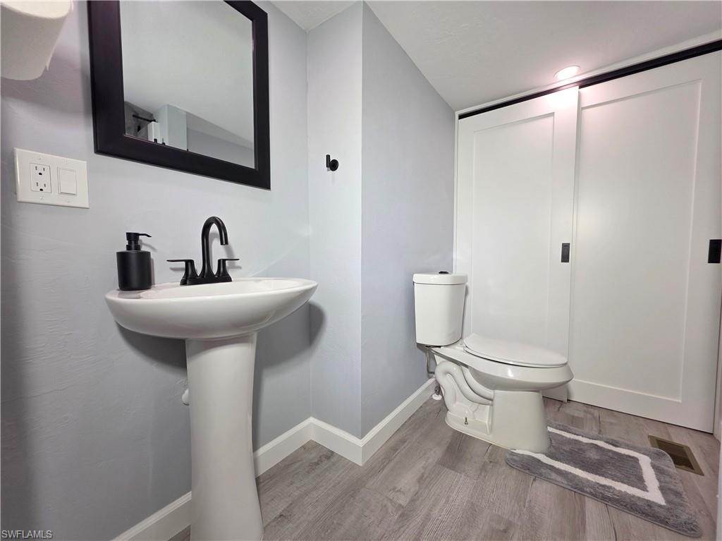 Half bathroom featuring wood finished floors and baseboards