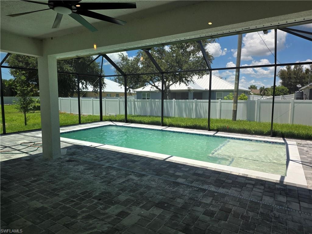 Screened-in outdoor living space featuring a rectangular swimming pool with a sun shelf