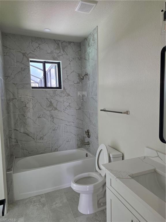 Modern bathroom featuring a white bathtub with tile surround, a single vanity with a white countertop and integrated sink, and gray tile flooring