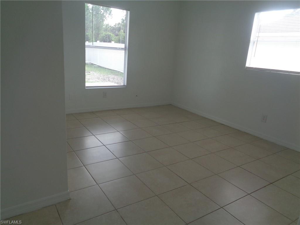 Unfurnished bedroom 2 with baseboards and light tile patterned floors