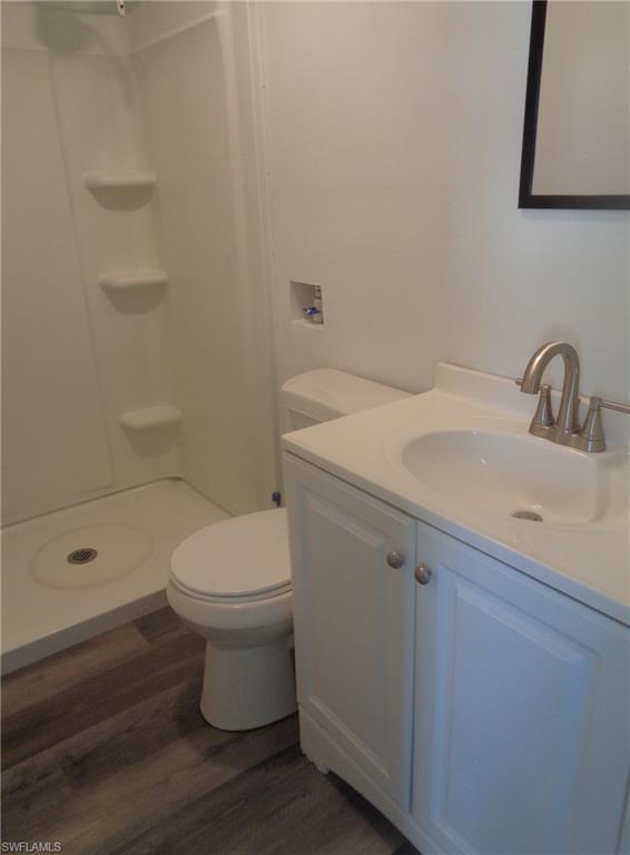 Bathroom of permitted 2 bed / 1 bath apartment with vanity, wood finished floors, and a shower