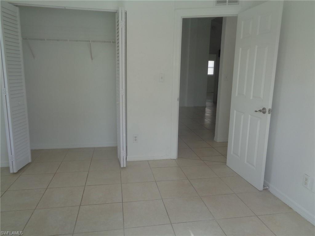 Unfurnished bedroom 1 with light tile patterned flooring and a closet
