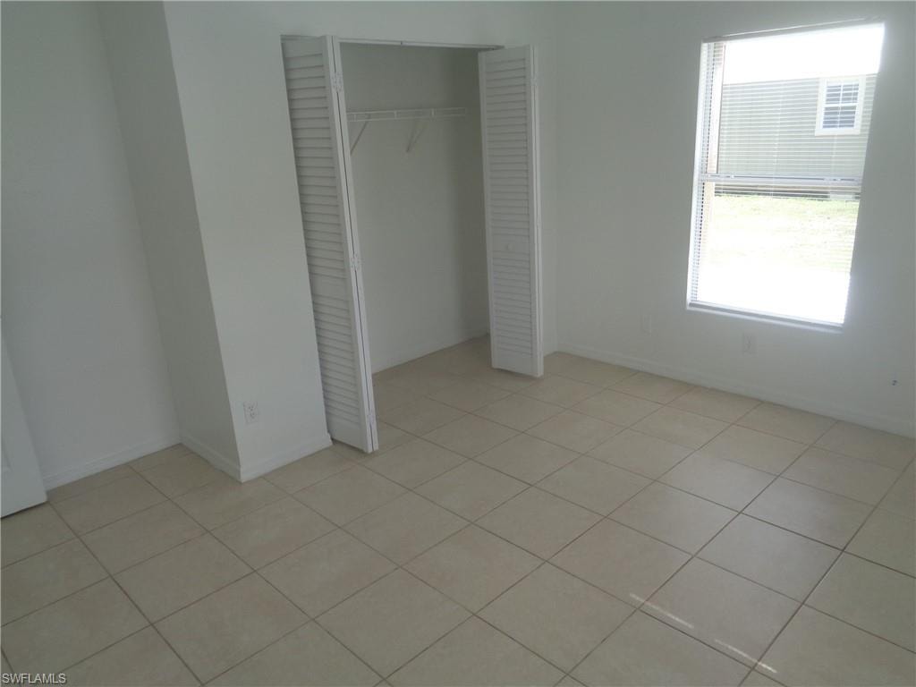 Unfurnished bedroom 2 with a closet and light tile patterned floors