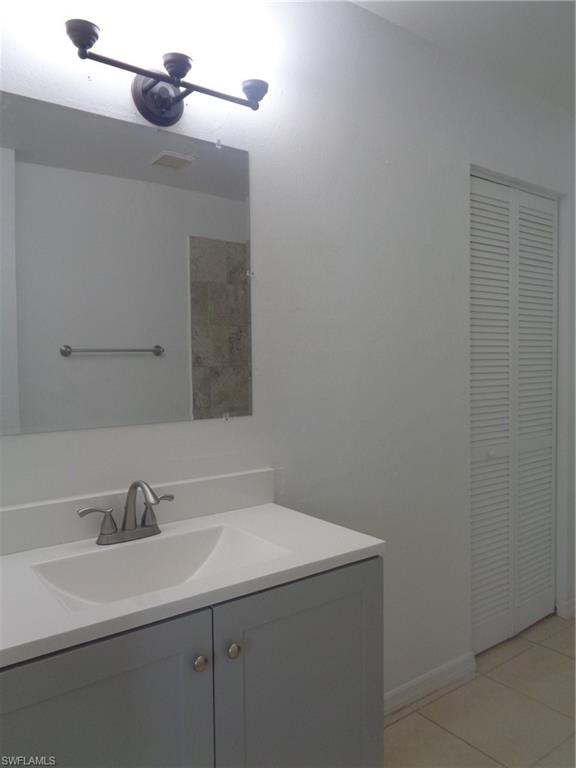Master bedroom bathroom with vanity, a closet, and tile patterned floors