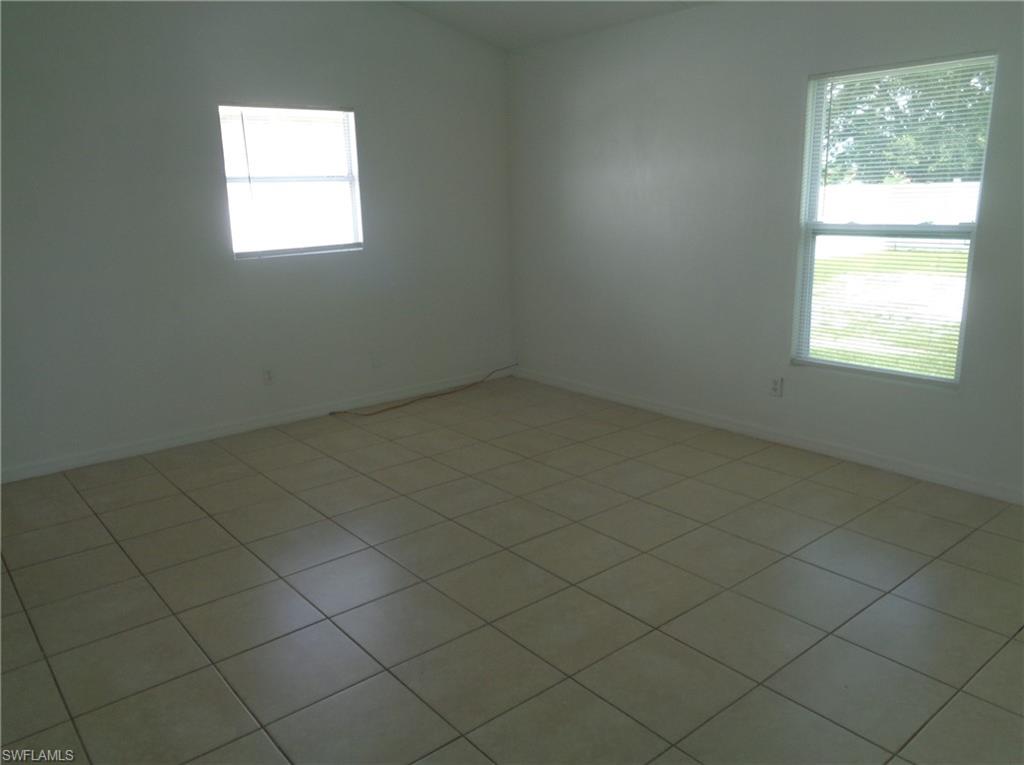 Unfurnished master bedroom with lofted ceiling and light tile patterned floors