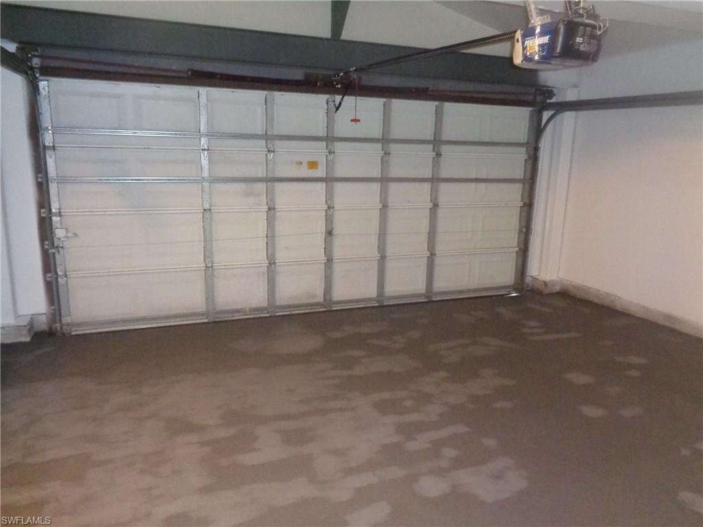 Garage with a garage door opener and baseboards