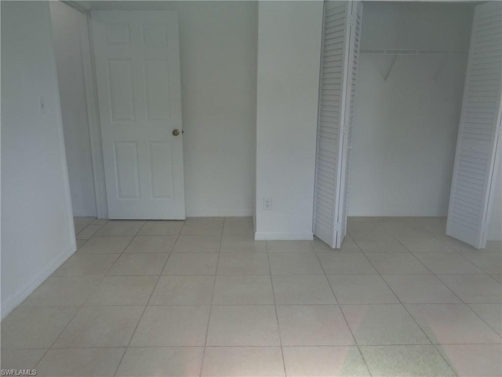 Unfurnished bedroom 2 with light tile patterned floors and a closet