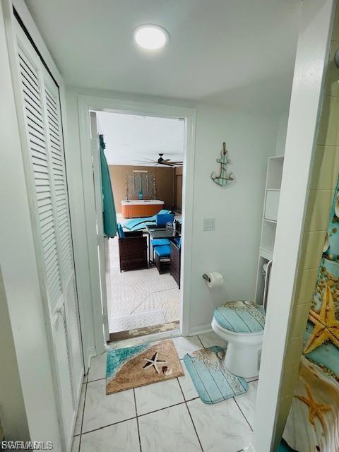 Full bath with a closet, tile patterned flooring, and a ceiling fan