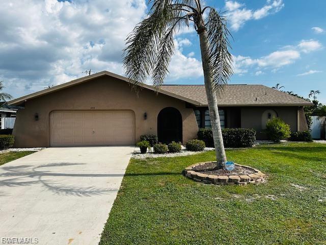 Ranch-style house featuring stucco siding, an attached garage, a front lawn, and concrete driveway