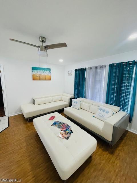 Living area featuring wood finished floors, ceiling fan, and recessed lighting