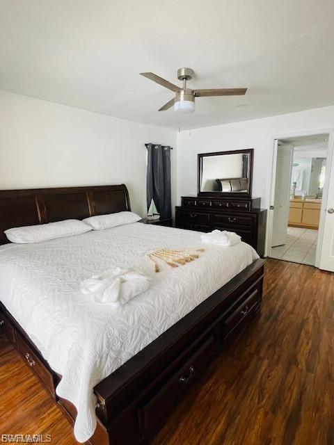 Bedroom with dark wood finished floors, ceiling fan, and connected bathroom