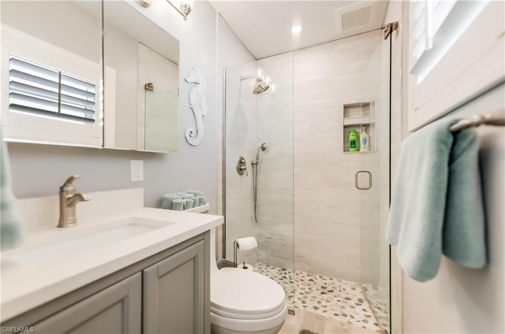 Full bathroom with vanity, a stall shower, and recessed lighting