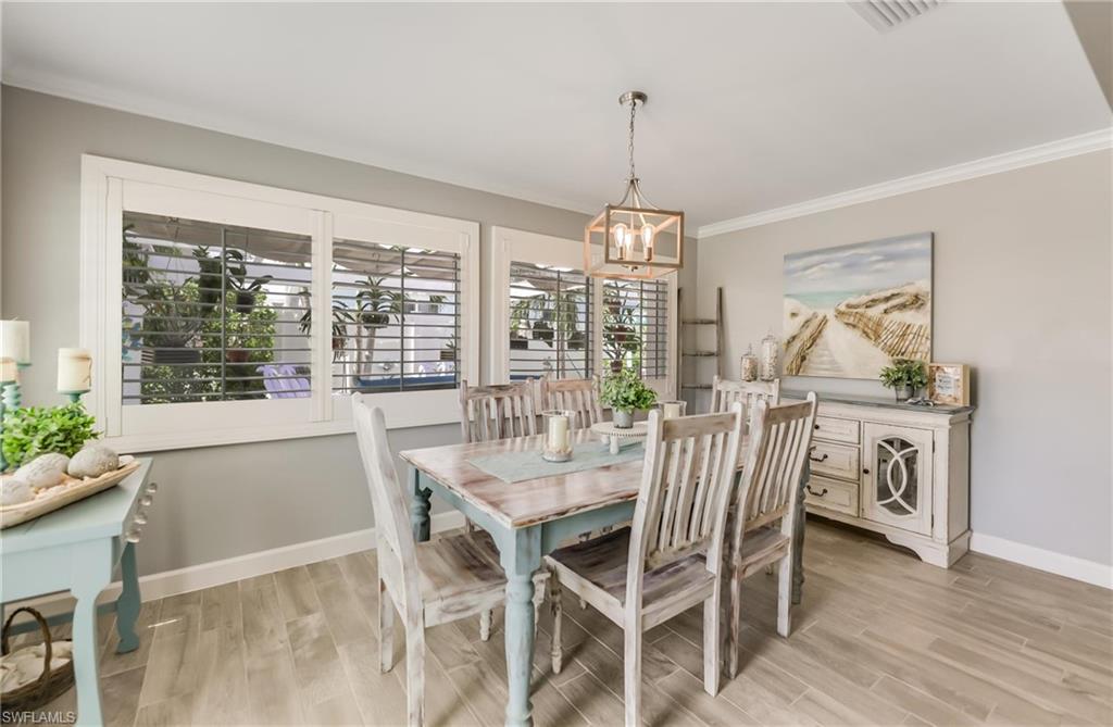 Dining area with a chandelier, crown molding, and light wood finished floors