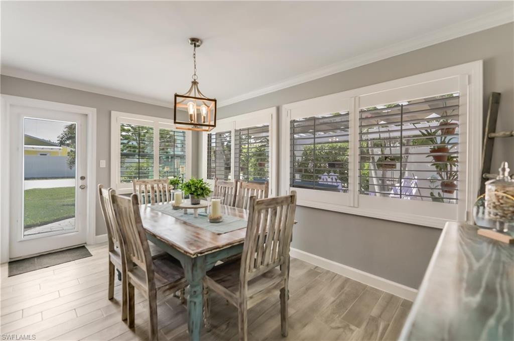 Dining area featuring a chandelier, ornamental molding, and wood finished floors