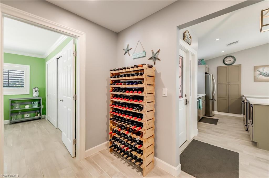 Wine cellar featuring light wood-style floors and ornamental molding