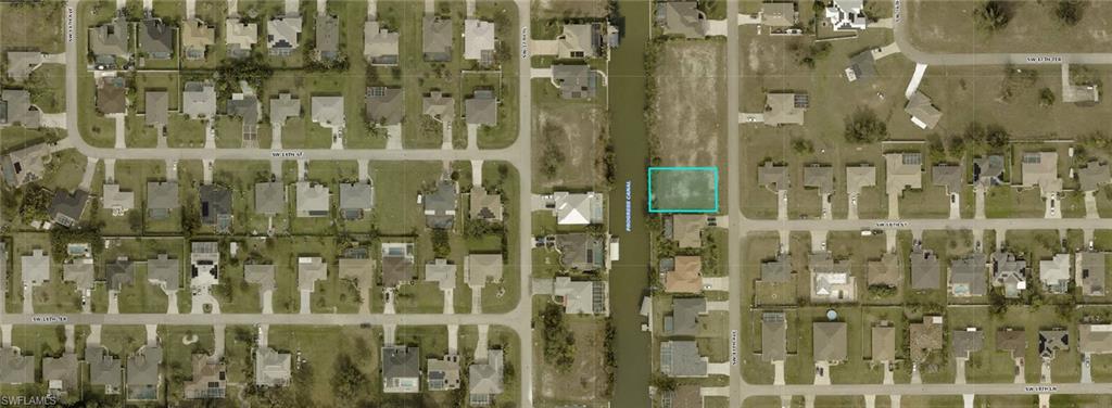 Aerial perspective of suburban area featuring property boundaries highlighted and a large body of water