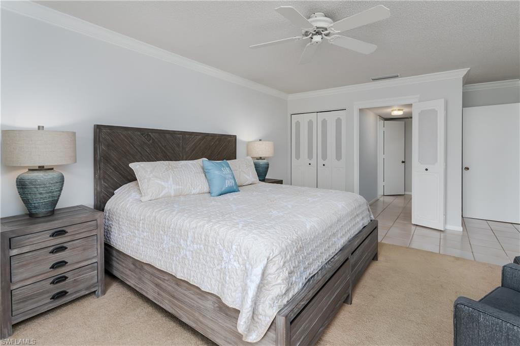 Bedroom featuring light carpet, and a ceiling fan