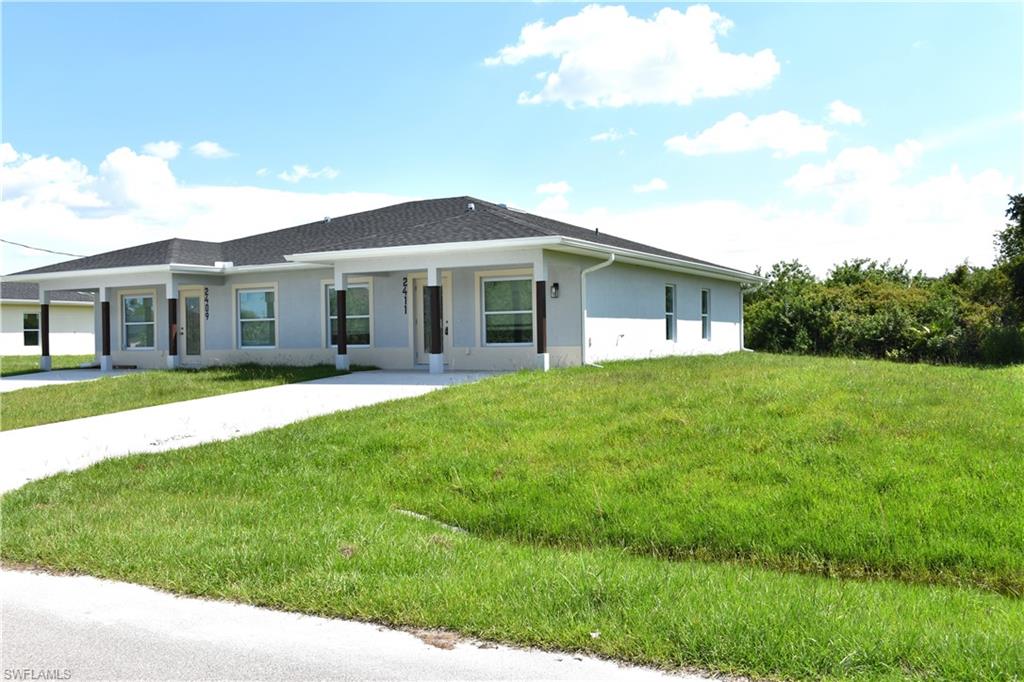 View of front of home with stucco siding and a front yard