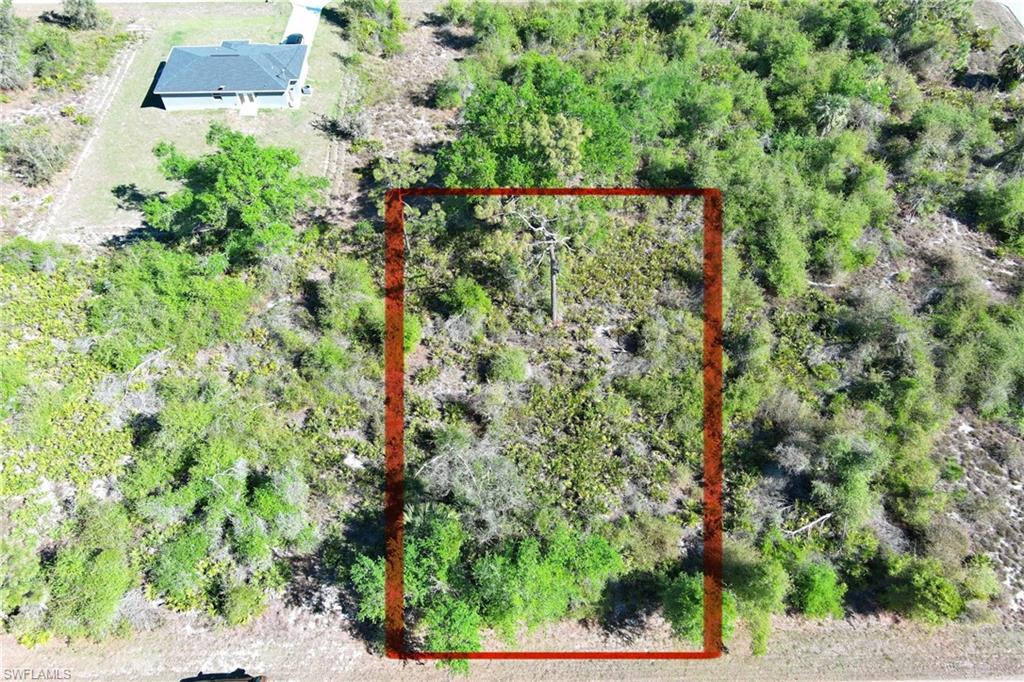 Aerial view of property and surrounding area with property parcel outlined