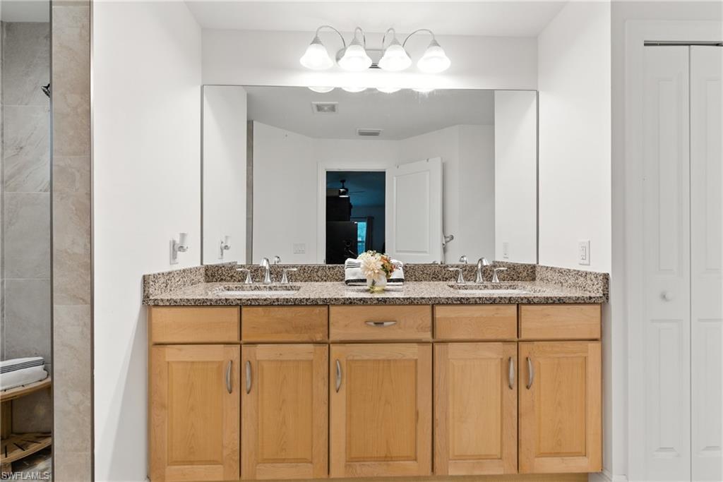 Bathroom featuring a closet and double vanity