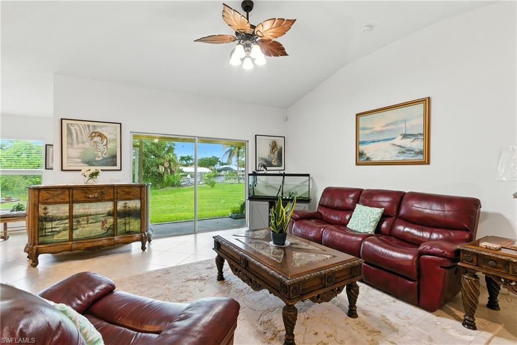 Tiled living room featuring vaulted ceiling and ceiling fan