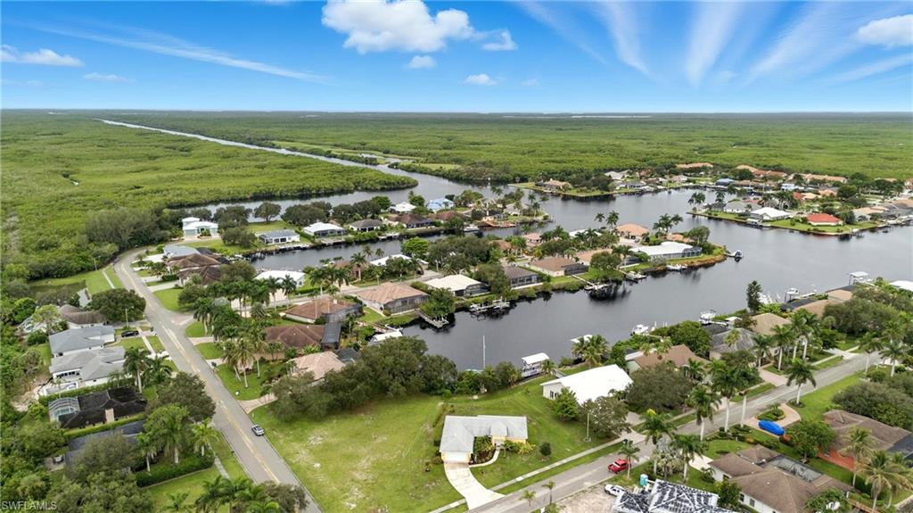 Aerial view of property and surrounding area with a large body of water and nearby suburban area