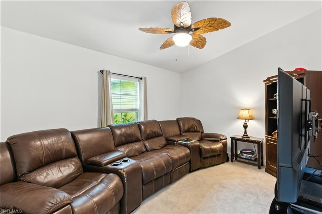 Living area featuring light colored carpet and a ceiling fan