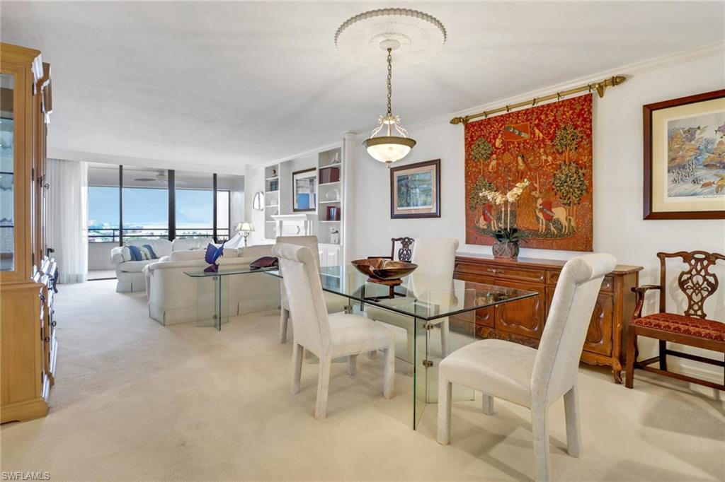 Carpeted dining space featuring a wall of windows and ornamental molding
