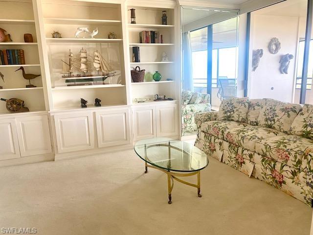 Living room featuring light carpet and built in shelves