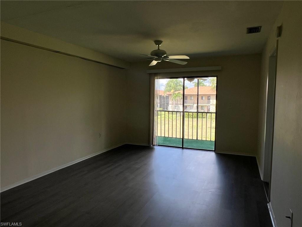 Empty room with ceiling fan and dark wood-style floors