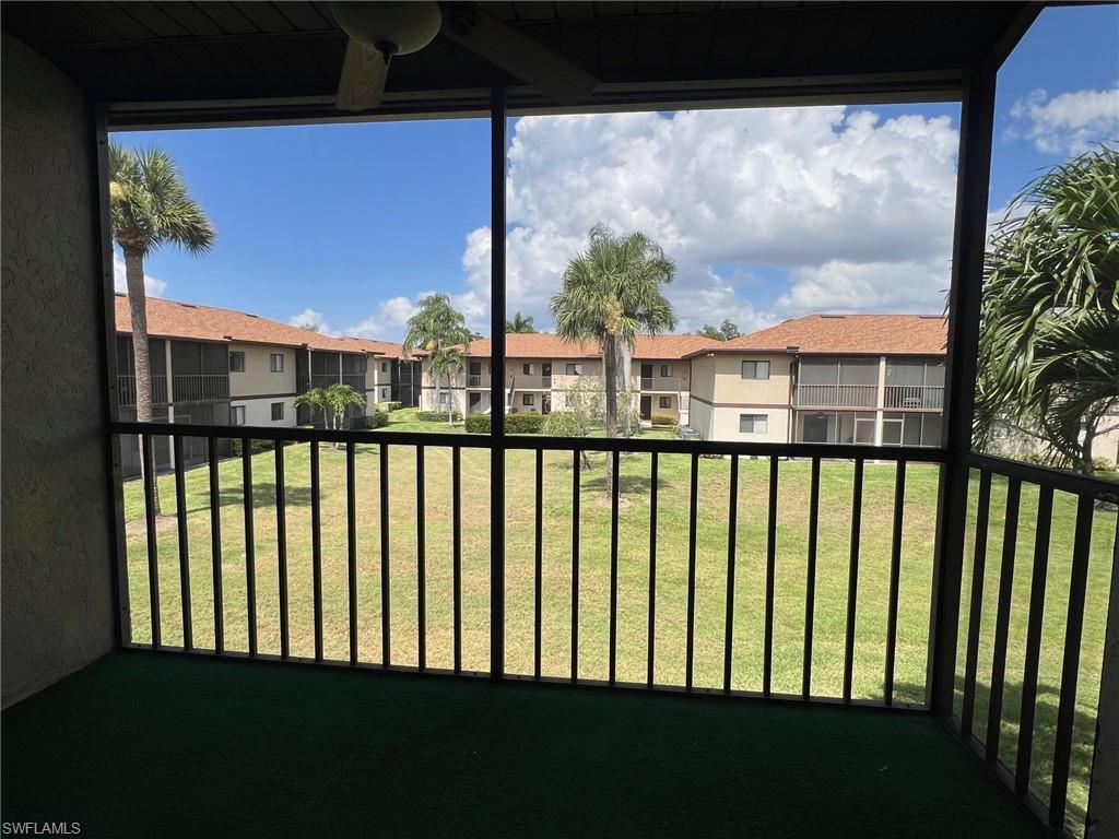 View of grassy yard featuring a balcony