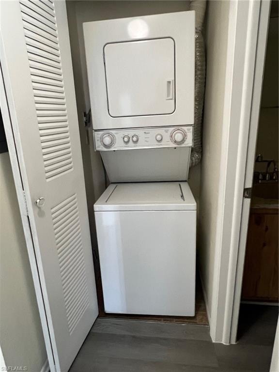 Laundry area featuring estacked washer and dryer and wood finished floors