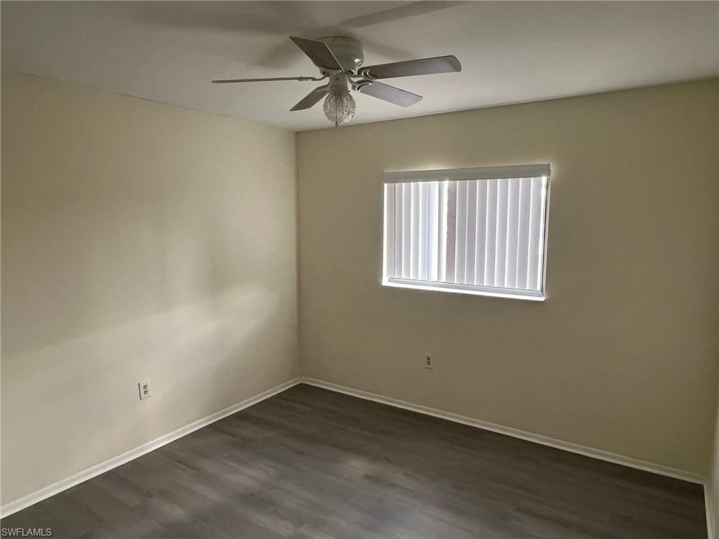 Spare room featuring dark wood finished floors and ceiling fan