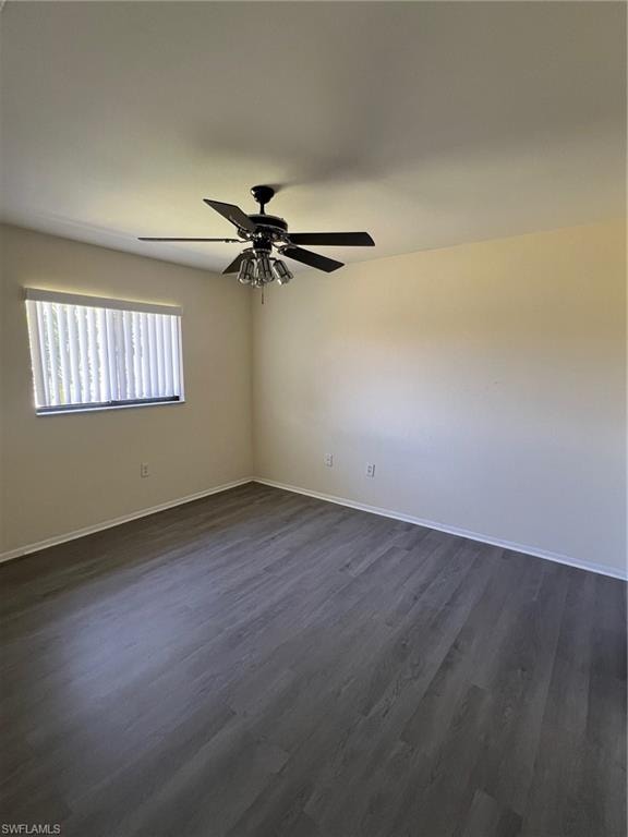 Empty room featuring dark wood-style flooring and ceiling fan