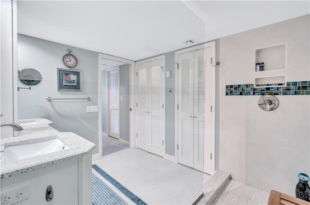 Full Primary bath with a closet, double vanity, and a tile shower