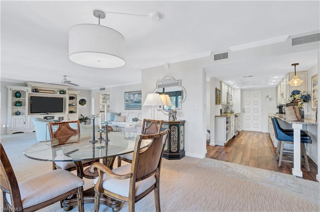Dining space featuring crown molding and light wood-style flooring